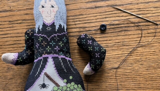 Doll with one arm attached and sculpture needle