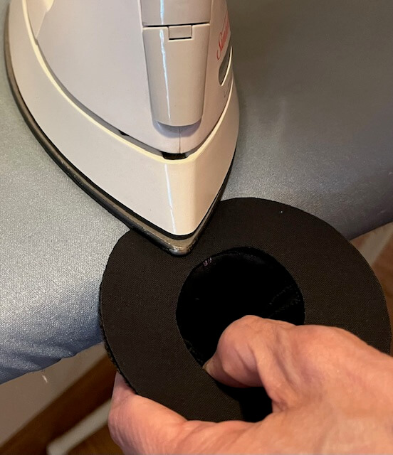 Iron fusing brim piece to underside of brim